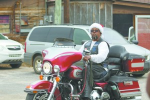 Bobby Ray Kent rides his motorcycle and throws out candy in the McKenzie Christmas parade. (Tori Norris/The Standard)