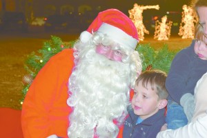 Connor Braden sits with Santa before Greenville's Christmas parade. (Bruce Branum/The Standard)
